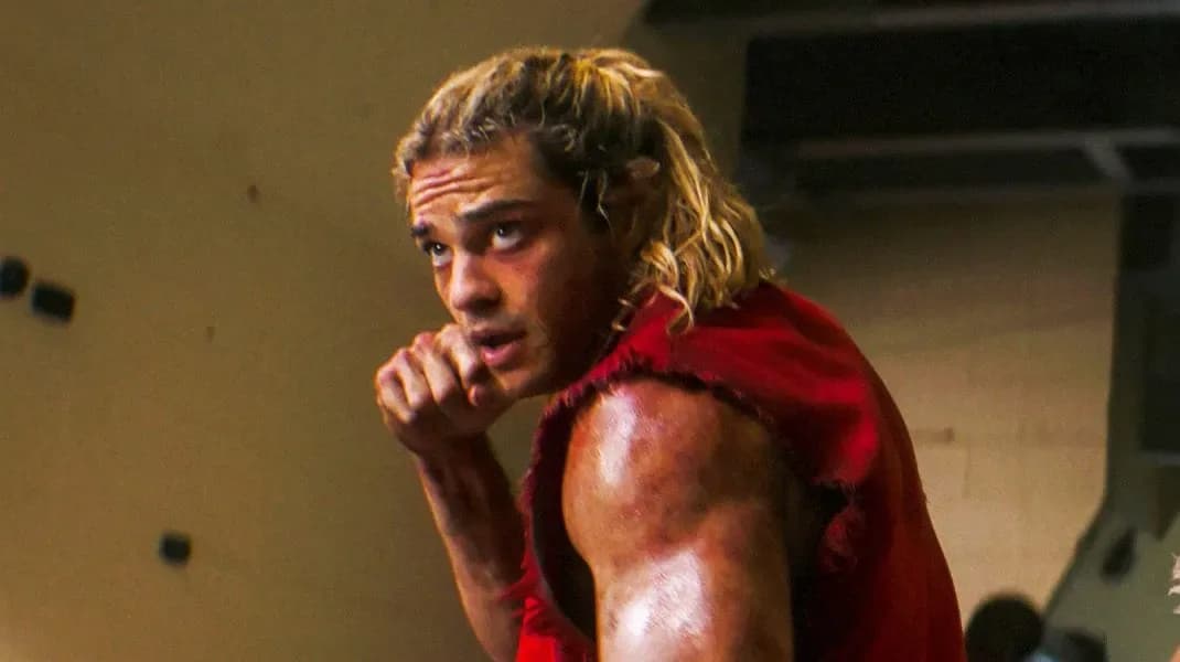 A still from the Street Fighter movie showing Noah Centineo as Ken Masters mid-punch, surrounded by dynamic motion blur.