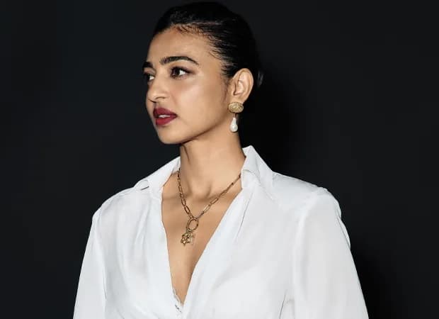 Radhika Apte smiling while holding a plate of sev puri in a casual kitchen setting