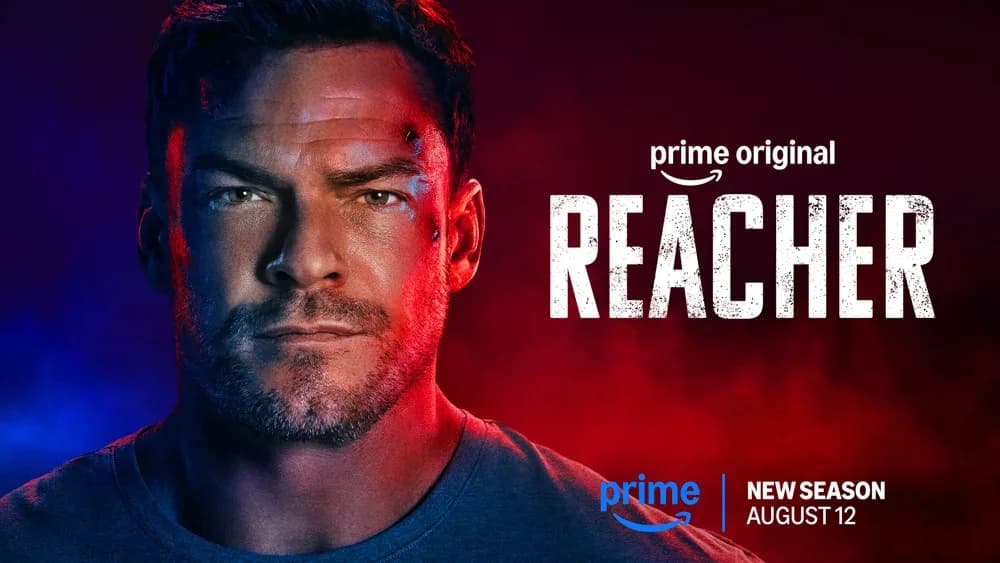 Alan Ritchson as Jack Reacher on the set of season five, with a Prime Video logo in the background.