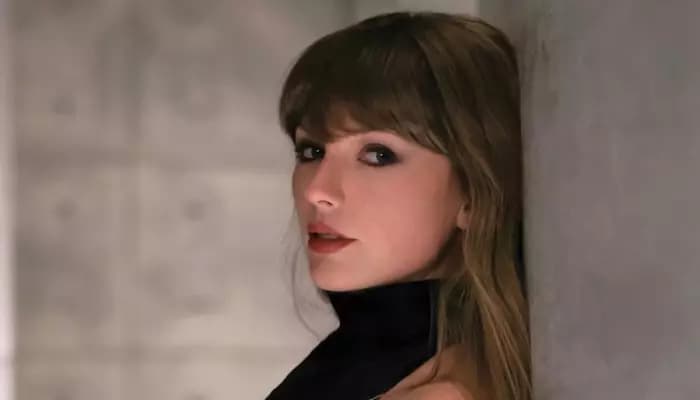 A gravestone scene from Taylor Swift's Patient Zero music video featuring Dakota Johnson placing a rose at the grave.