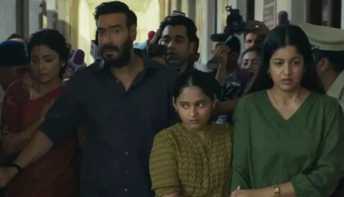Ajay Devgn in a rain-soaked scene, standing alone, face half-shadowed, as the camera pulls back.