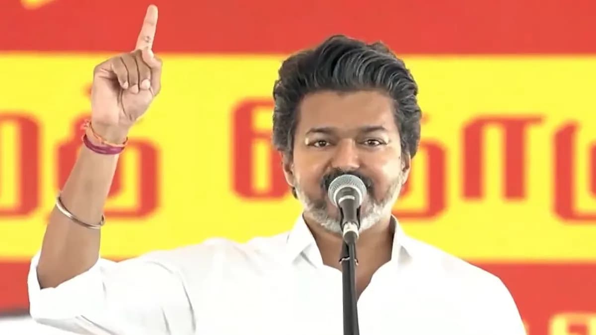 Campaign rally in Dharapuram with Vijay addressing a crowd of supporters under a banner reading TVK