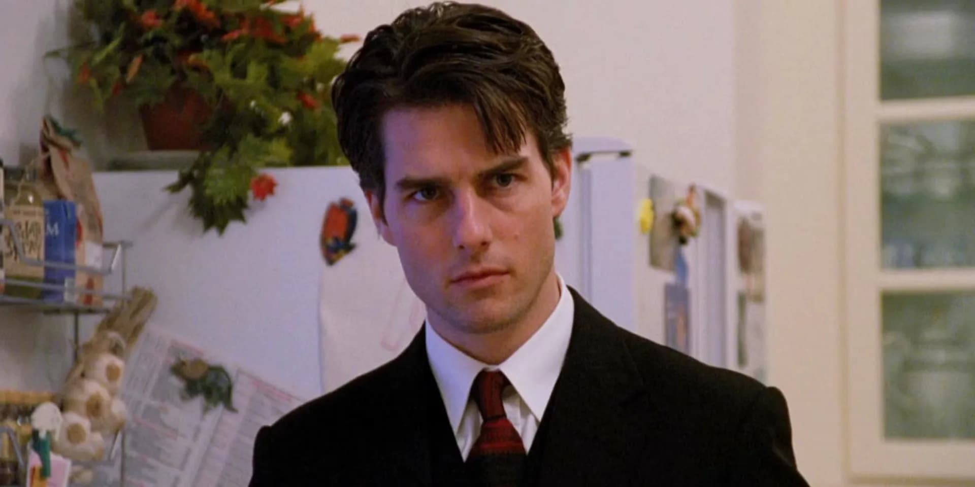 Tom Cruise in a suit, walking through a snow-covered New York street, looking uneasy.