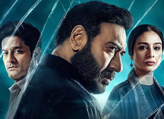 Ajay Devgn in a tense expression, standing in front of a police station, shadows behind him.