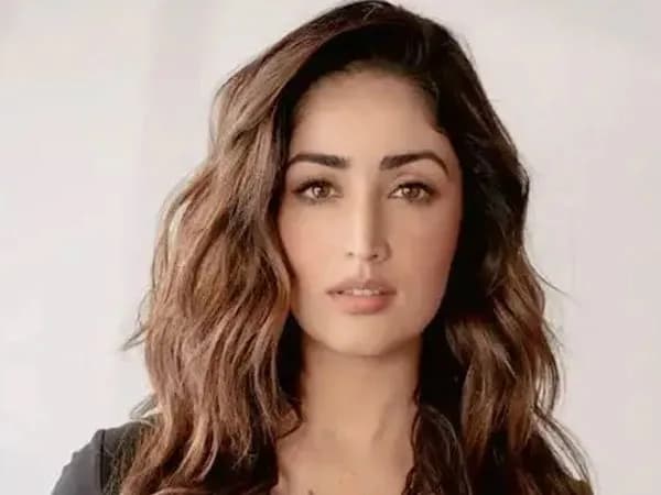 Yami Gautam standing in front of a cinematic backdrop, looking directly at the camera with a serious expression.