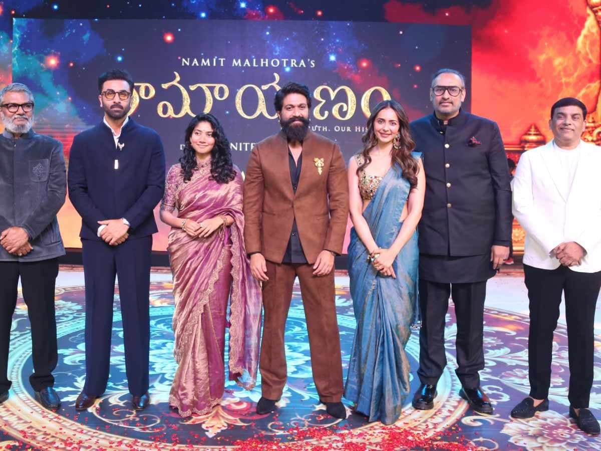 Ranbir Kapoor speaking at a pre-release event for Ramayana in Hyderabad, surrounded by cast and crew.