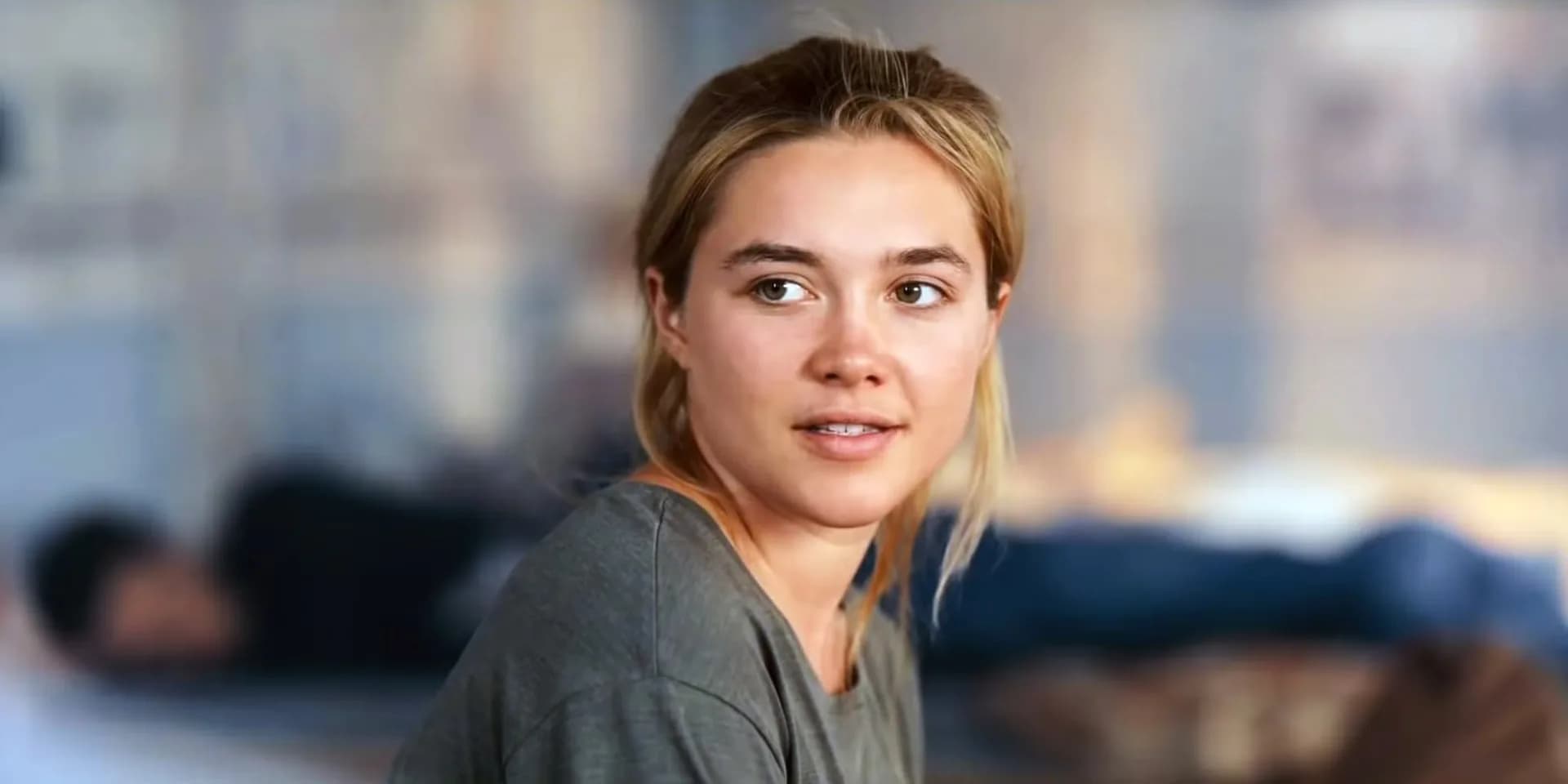 Florence Pugh in a white dress, standing in a field of flowers, eyes wide with terror.
