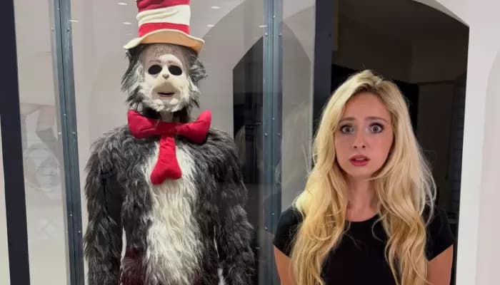 The furry, red-and-white striped Cat in the Hat costume worn by Mike Myers, displayed with its rubber mask and gloves.