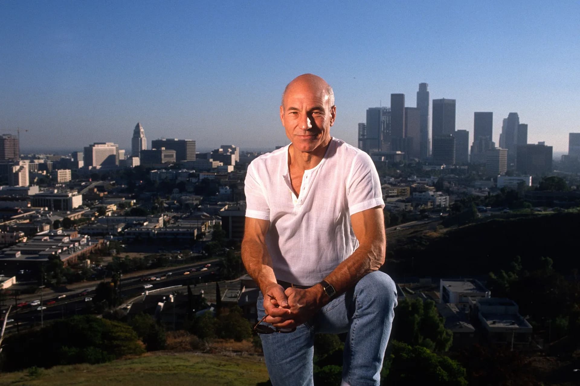 Sir Patrick Stewart smiling in a formal portrait, known for roles as Jean-Luc Picard and Professor X.