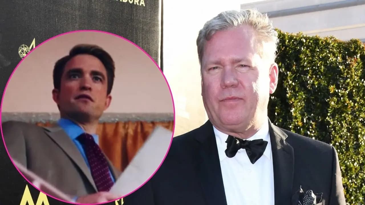 Robert Pattinson in character as Chris Hansen, wearing a suit and holding a notebook, standing in front of a newsroom backdrop.