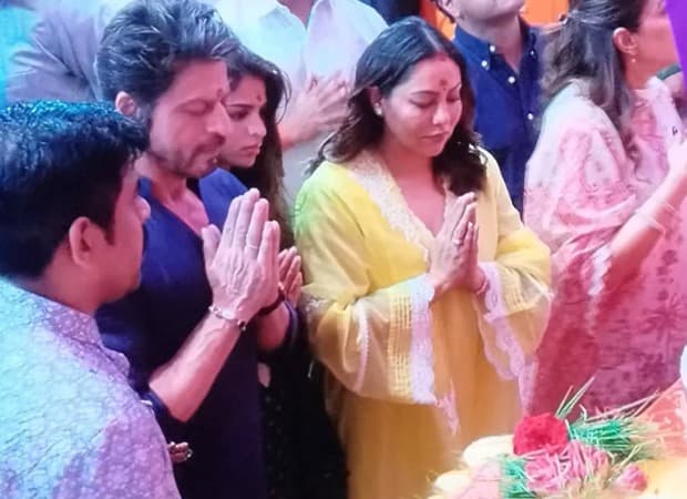 Shah Rukh Khan in a blue kurta, Gauri Khan in yellow, and Suhana Khan in emerald green stand before the Lalbaugcha Raja Ganesh idol