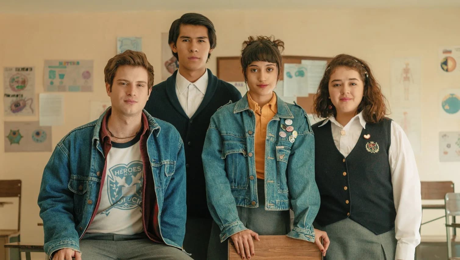 A group of teenagers in 90s-style clothes standing in a dimly lit hallway, looking at each other with quiet defiance. A notebook lies open on the floor, filled with scribbled notes and doodles.