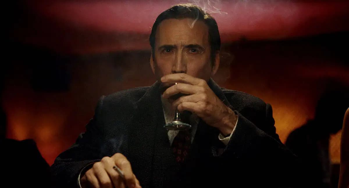 Nicolas Cage at New York Comic Con, mid-speech, grinning at a cheering crowd.