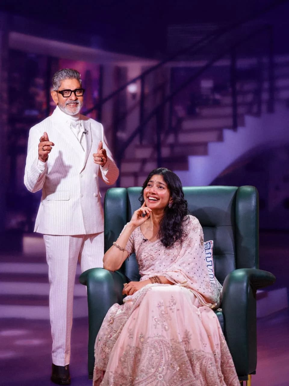 Sai Pallavi seated across from Jagapathi Babu in a relaxed talk show setting, smiling softly