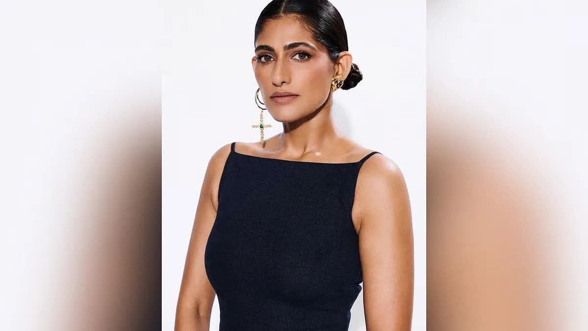 Kubbra Sait speaking into a microphone at a public event