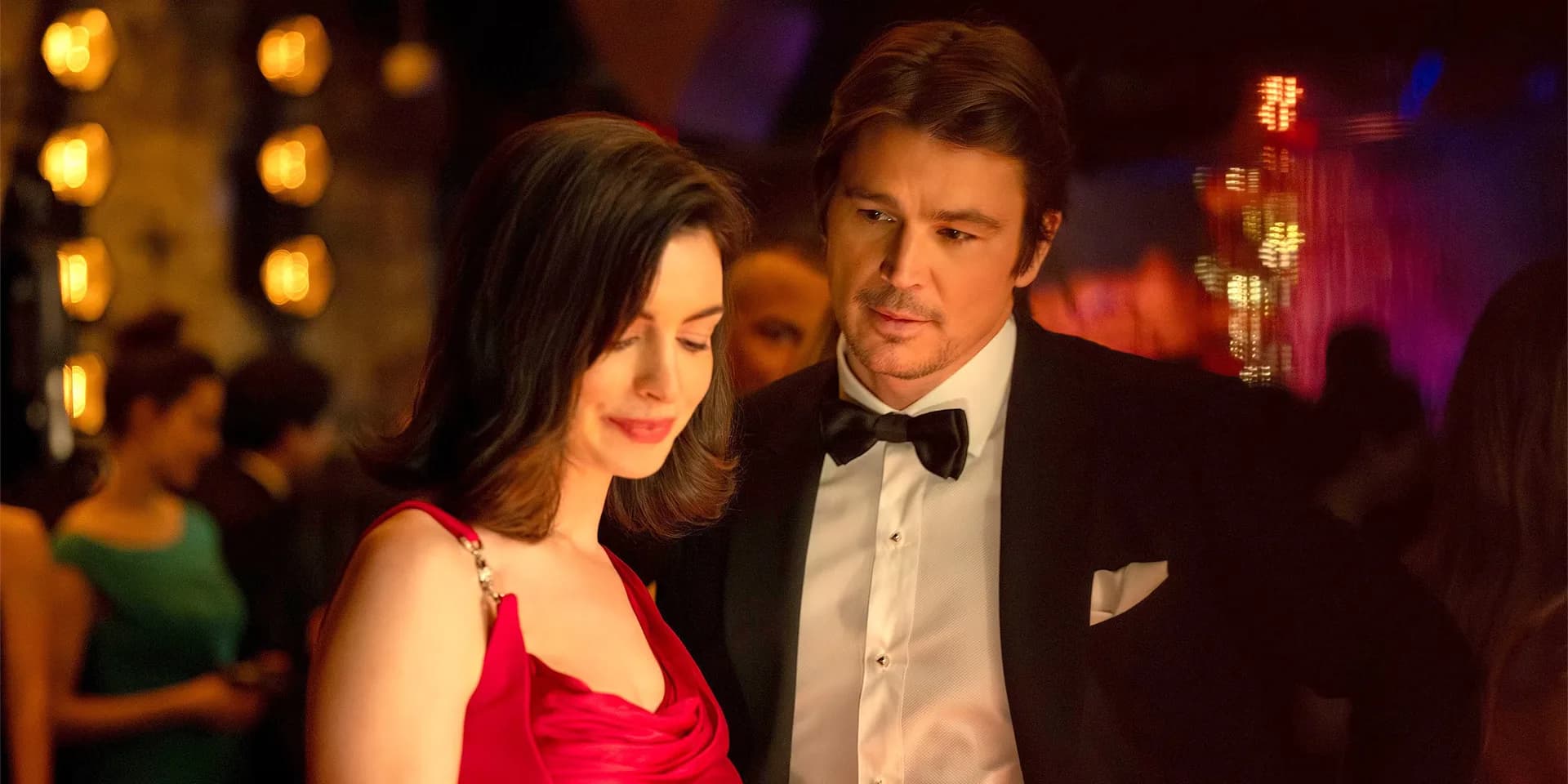 Anne Hathaway in a tense scene from Verity, eyes locked on camera, shadows playing across her face.