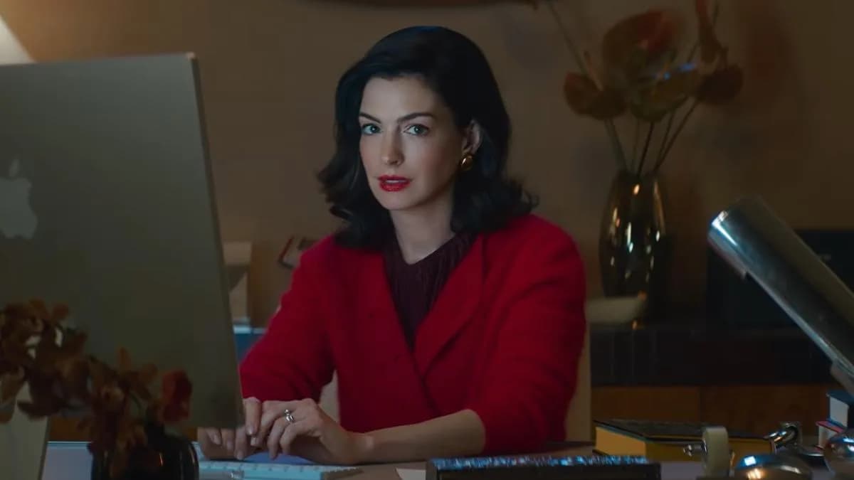 Anne Hathaway as Verity Crawford seated in a wheelchair beside a glass table in the film Verity