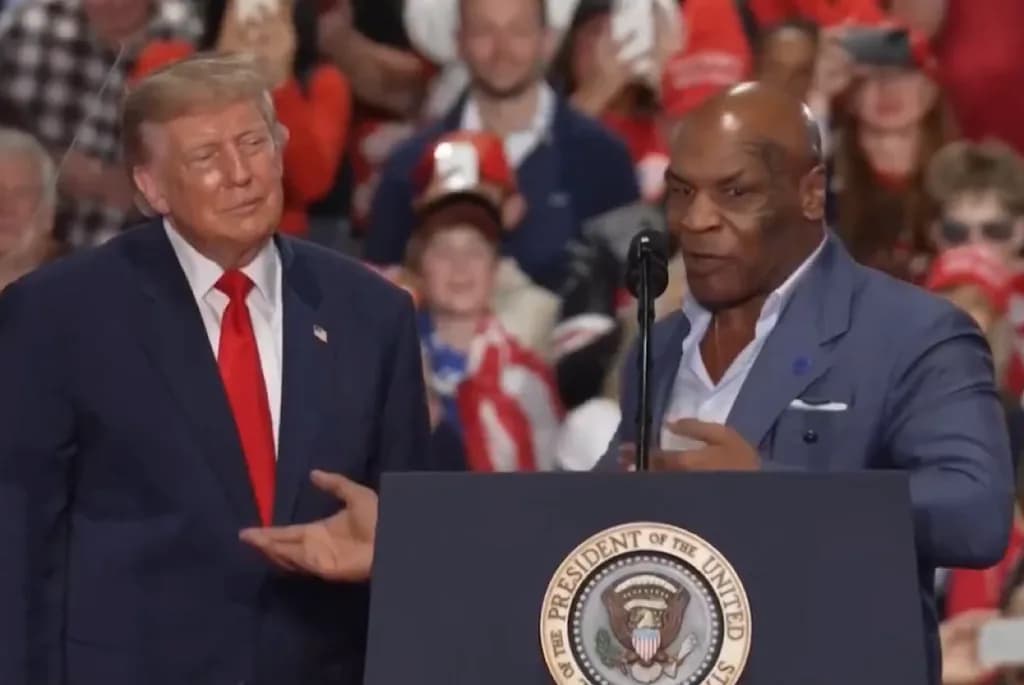 Mike Tyson and Donald Trump standing side-by-side at a podium during a political rally.