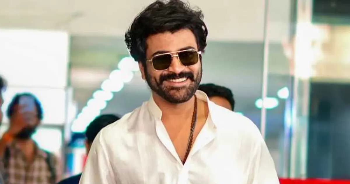 Sharwanand standing on a film set, wearing casual clothing, with crew and equipment in the background