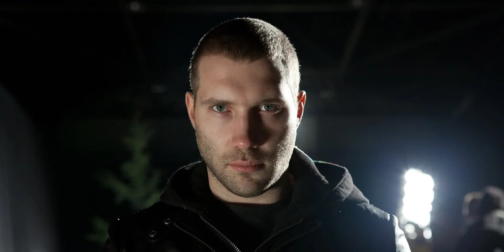 Tom Cruise as Jack Reacher in a promotional still for the 2012 film, standing in a dimly lit urban alley.