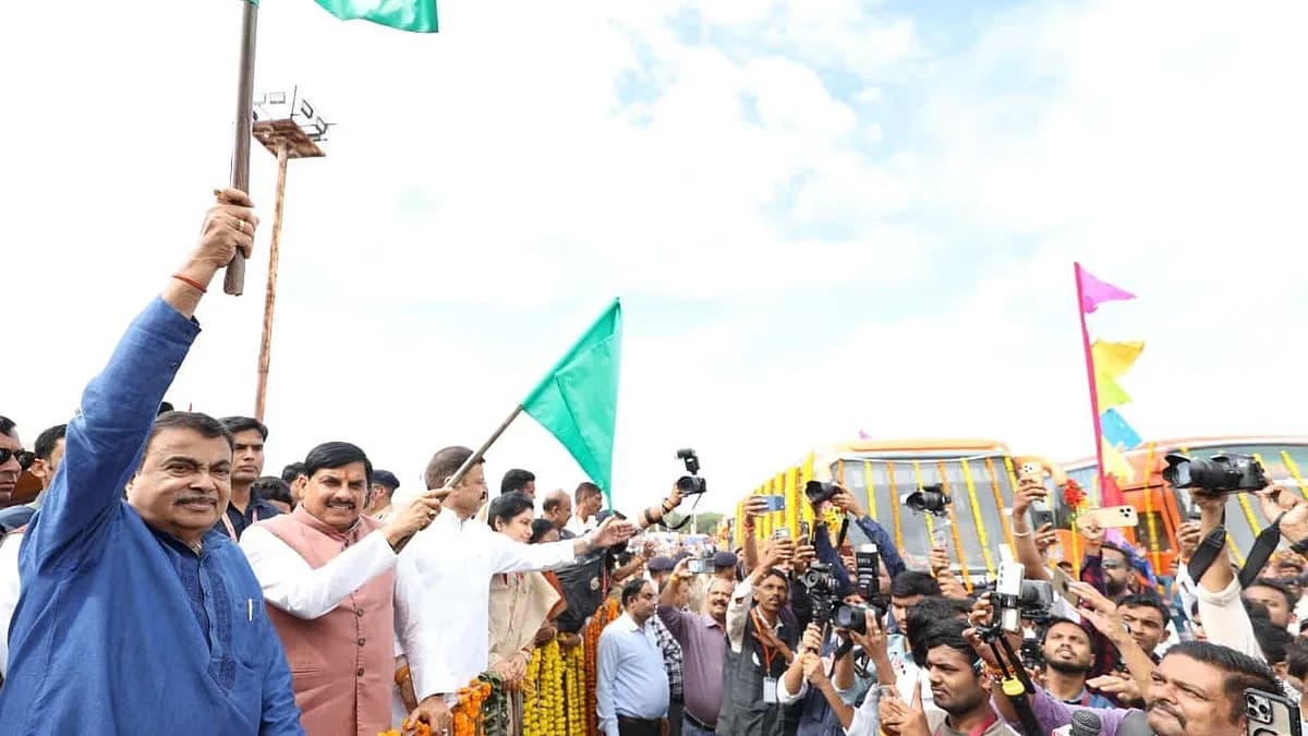 Nitin Gadkari and Mohan Yadav stand near a row of new state buses during the launch event in Bhopal.
