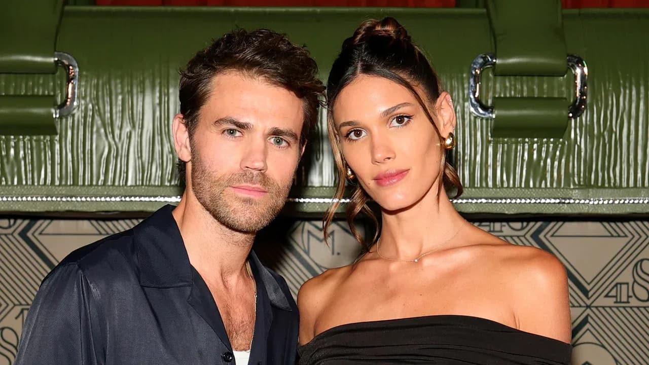 Paul Wesley and Natalie Kuckenburg walking out of Hotel Costes in Paris at night, dressed casually but stylishly.