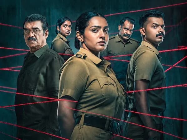Parvathy Thiruvothu in Pradhama Drishtya Kuttakkar, standing in a dimly lit police station, eyes sharp, holding a file.