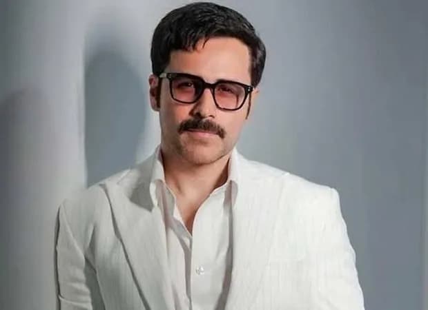 A dramatic shot of a car suspended mid-air, with Emraan Hashmi standing nearby, looking unharmed.