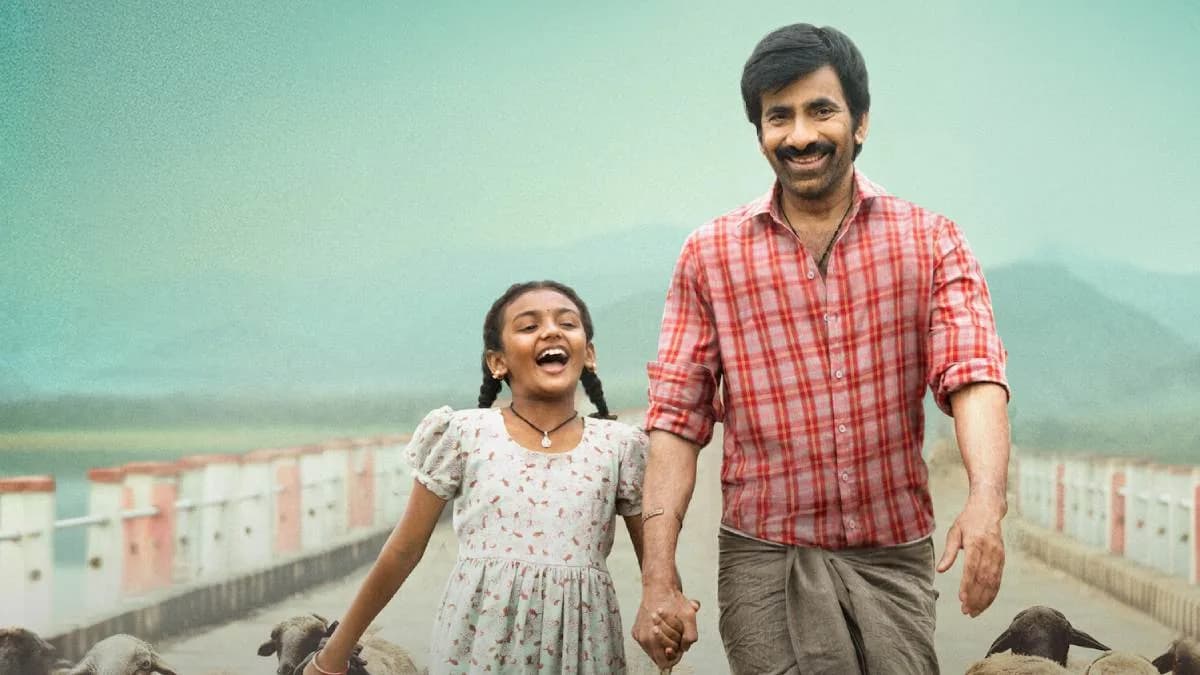 Ravi Teja in a dramatic pose from Irumudi, standing in front of a stormy sky.