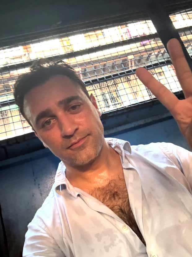 Imran Khan in a police van, holding up his phone with a selfie, captioned 'Apparently I'm going for a drive.'