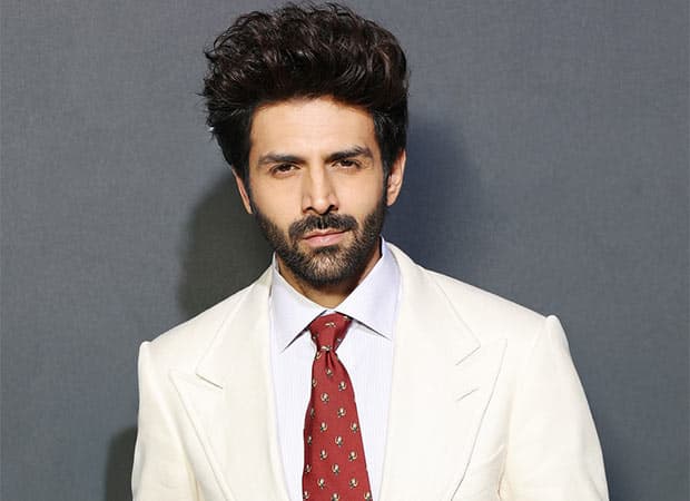Kartik Aaryan poses in an evening look while showcasing an Armani Exchange watch in a promotional teaser.