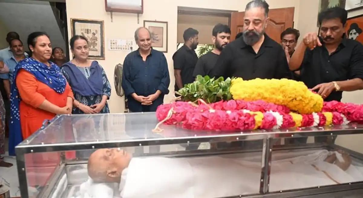 Kamal Haasan standing at the funeral of filmmaker Singeetham Srinivasa Rao, head bowed in grief.
