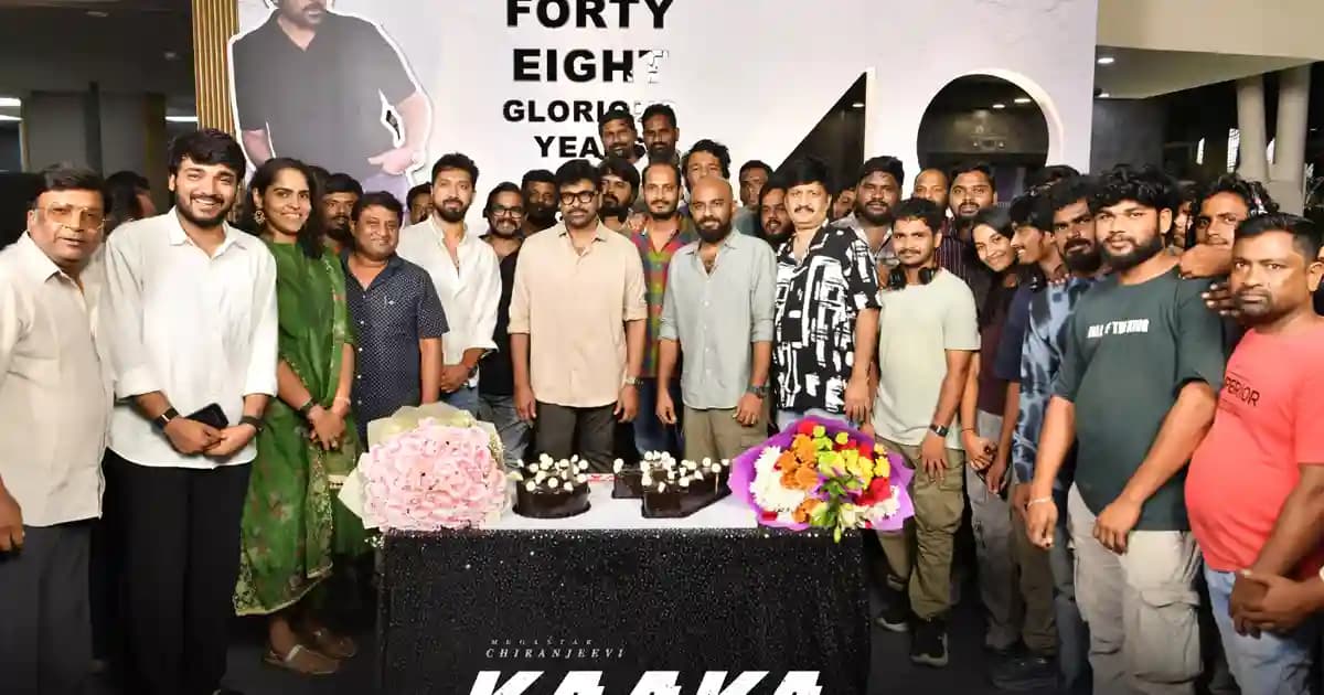 Chiranjeevi wearing a trimmed beard and glasses on the Kaaka set, surrounded by crew and a celebratory cake.