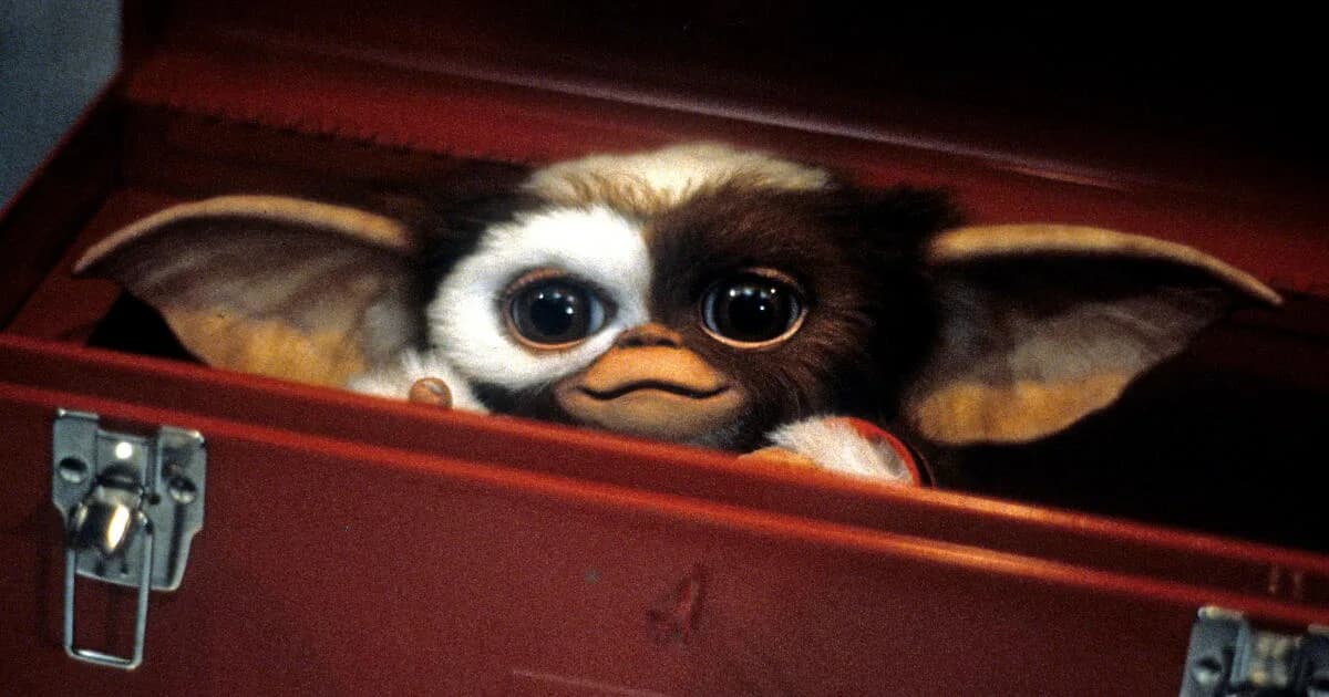 Teaser screenshot showing Gizmo peeking out of a backpack with the text Oct 8 2028 overlaid