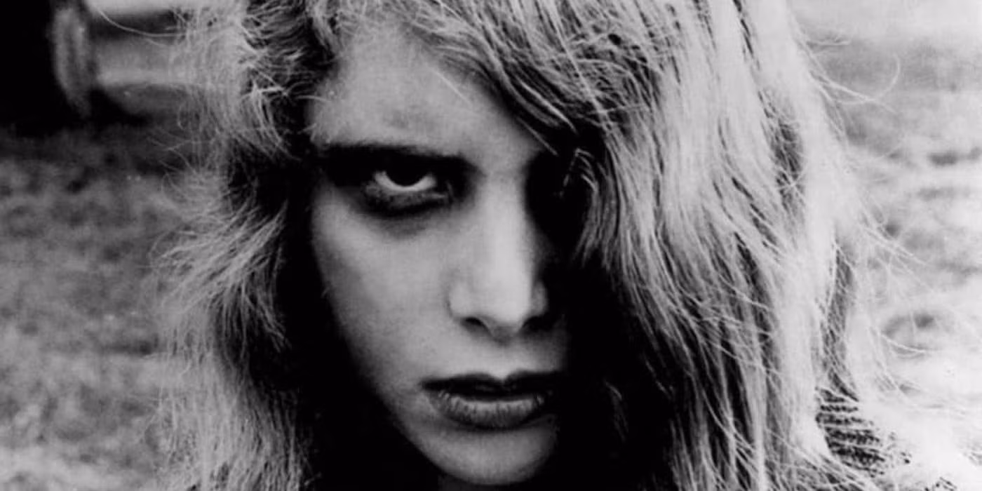 Black and white still from Night of the Living Dead showing a zombie reaching through a barricaded farmhouse door.