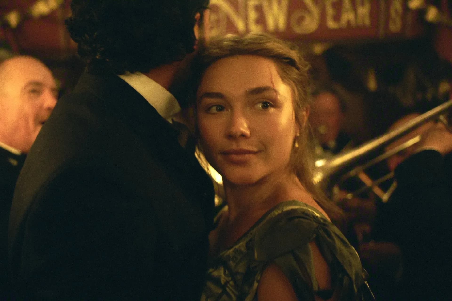 Florence Pugh as Cathy Ames in a dimly lit room, eyes sharp, face half-shadowed.