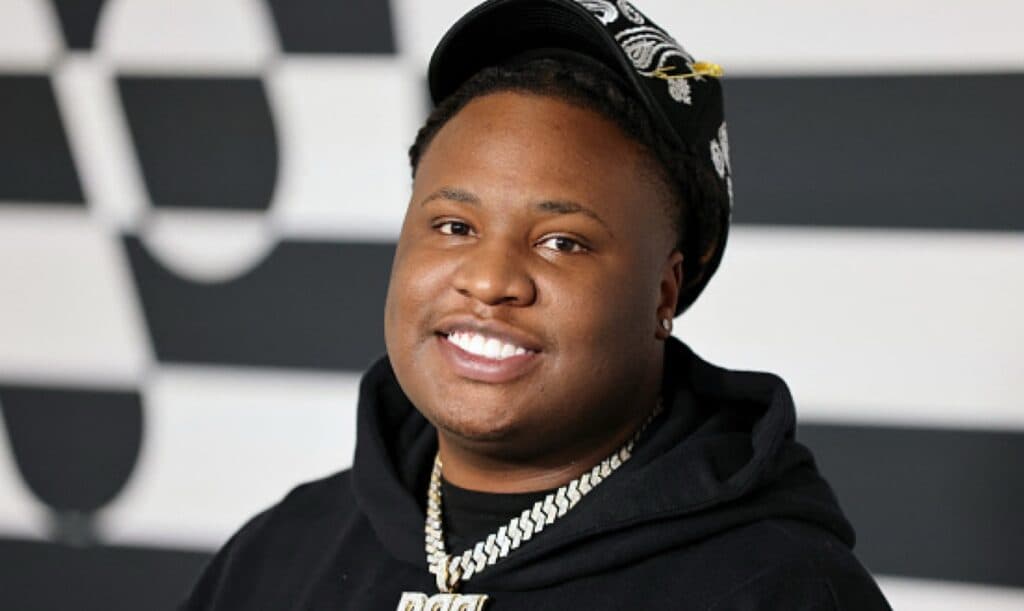 Music producer Tay Keith performing on stage with headphones around his neck