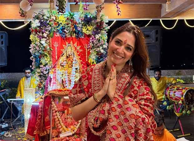 Tamannaah Bhatia in traditional attire at a devotional gathering, eyes closed, hands folded in prayer