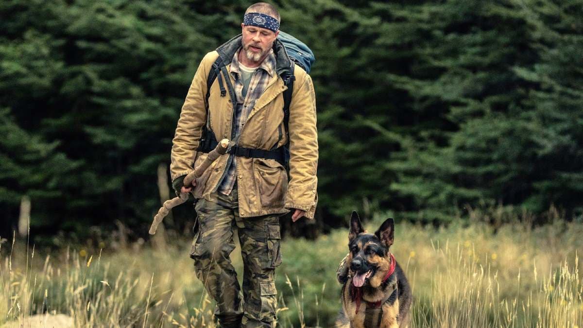 Brad Pitt holding a pocketful of boiled chicken while a dog stands beside him on the Heart of the Beast set