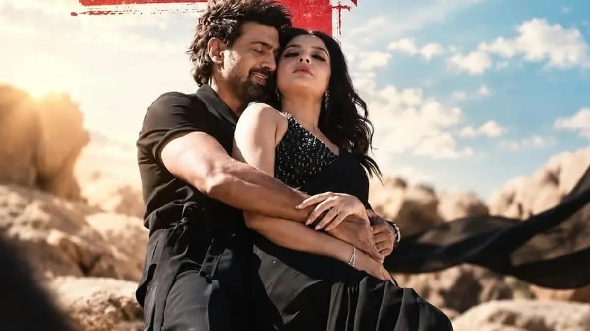 A promotional poster for DeSu7 featuring Dev and Subhashree Ganguly standing in front of a stormy sky, with bold text reading 'DeSu7' in red and gold.