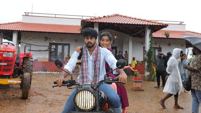 A still from Premada Oorali showing actors in a rural setting, with a simple, emotional expression