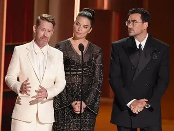 Macaulay Culkin, Annie Murphy and Dan Levy stand together on stage at the 2026 Emmys during the tribute to Catherine O'Hara