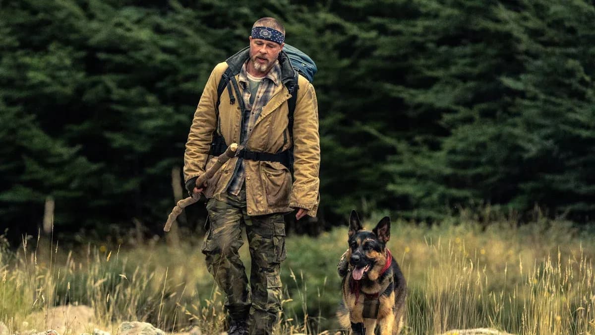 Brad Pitt stands in Alaskan snow beside German Shepherd Odin from Heart of the Beast
