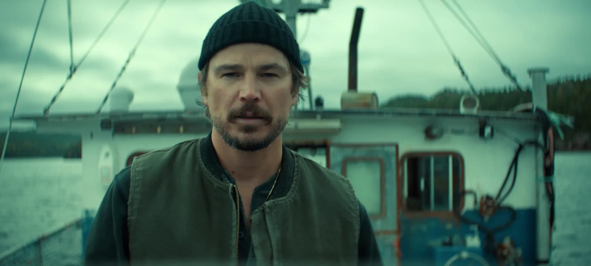 Josh Hartnett as Calvin Penney, standing on a rocky shore, looking out at a stormy ocean.