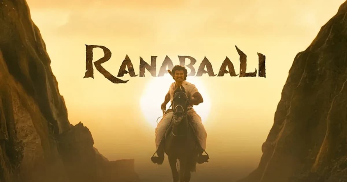 A still from Ranabaali showing a remote village with dense forest and a single road leading into the unknown.