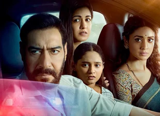 Ajay Devgn in a tense scene from Drishyam 3, standing in front of a police station under dim light