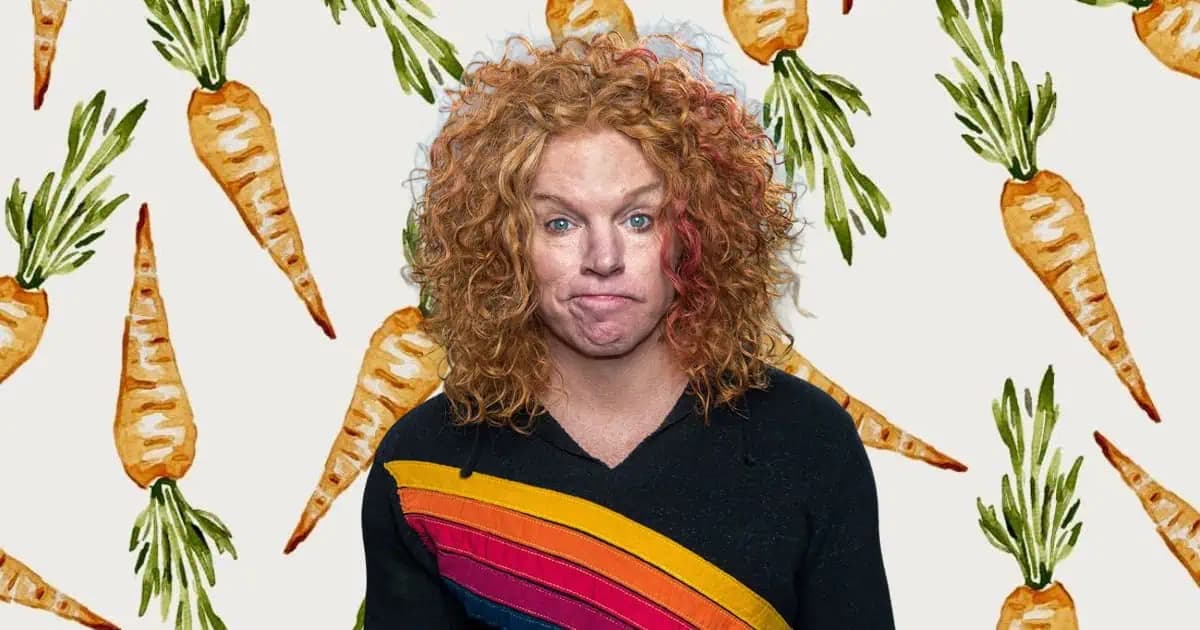 Carrot Top performing on stage in Las Vegas with his trademark frizzy red hair and custom comedy props.