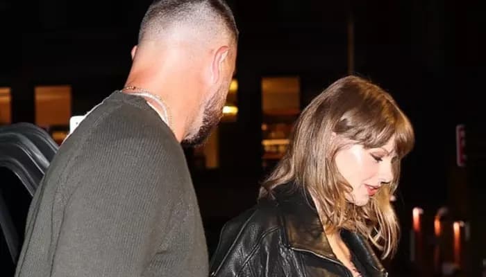 Taylor Swift and Travis Kelce walking into an Italian restaurant in New York, holding hands.