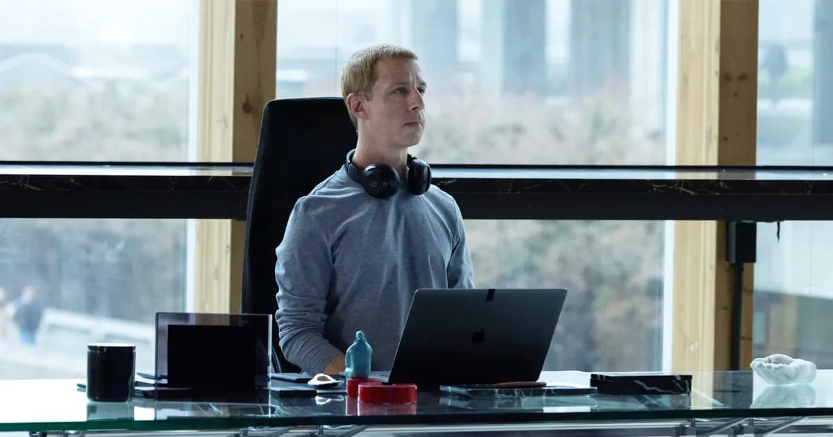 A dimly lit scene from The Social Reckoning showing Mikey Madison and Jeremy Allen White in a tense office confrontation, with Jeremy Strong in silhouette behind them.