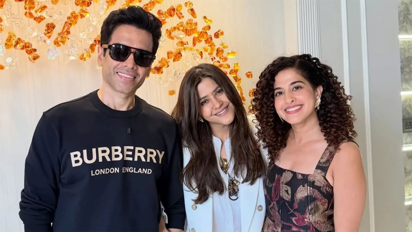 A still from a promotional video showing Kamiya Jani sitting at a table with Ekta Kapoor and Tusshar Kapoor, smiling over food.